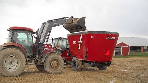 625 mixer getting dumped into by tractor.